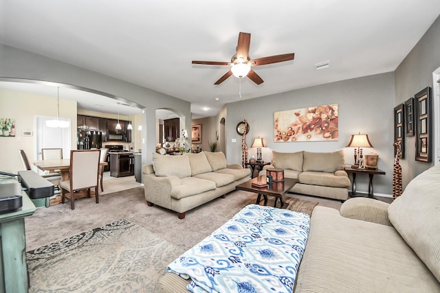 9703 Tipton Sands Dr, Humble, TX 77396 - living room featuring arched walkways, ceiling fan, and light colored carpet