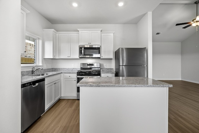 377 Tejas Trl, Waller, TX 77484 - kitchen featuring appliances with stainless steel finishes, light wood-style floors, white cabinetry, a kitchen island, and ceiling fan