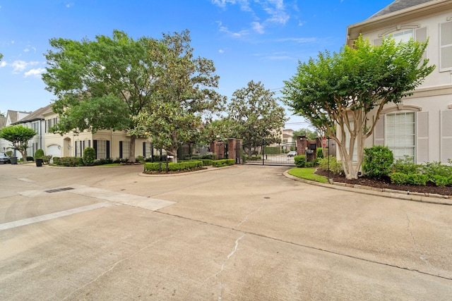 3219 N Pemberton Circle Dr, Houston, TX 77025 - view of concrete road with a gate, curbs, a residential view, and a gated entry