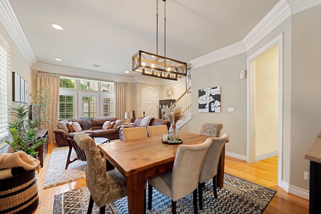 3219 N Pemberton Circle Dr, Houston, TX 77025 - dining room featuring light wood-style flooring, baseboards, ornamental molding, stairs, and a chandelier