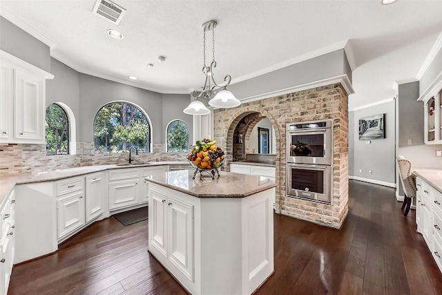 3230 Ivy Falls Dr, Houston, TX 77068 - kitchen featuring stainless steel double oven, a sink, ornamental molding, a kitchen island, and tasteful backsplash