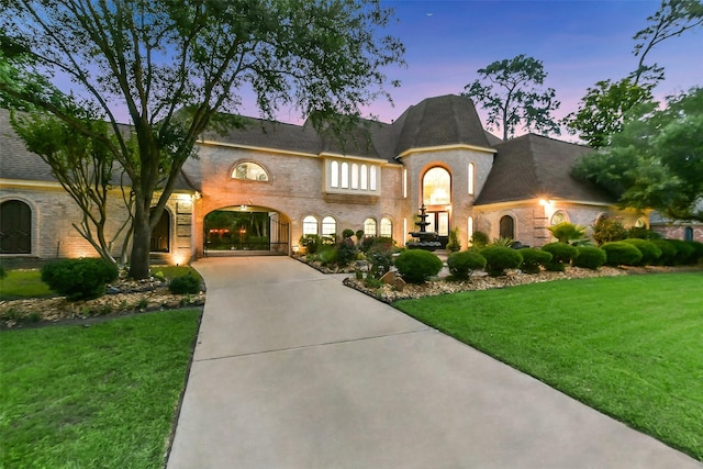 3230 Ivy Falls Dr, Houston, TX 77068 - french country style house featuring concrete driveway, a front lawn, and brick siding