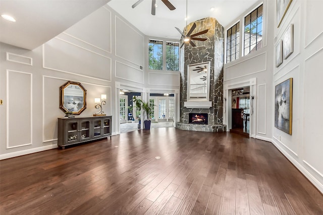 3230 Ivy Falls Dr, Houston, TX 77068 - unfurnished living room with a decorative wall, high vaulted ceiling, a ceiling fan, a fireplace, and wood finished floors