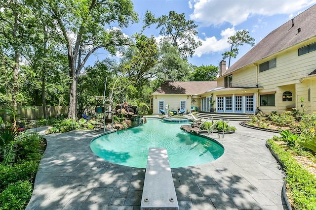 3230 Ivy Falls Dr, Houston, TX 77068 - view of swimming pool with a patio area, fence, a diving board, a pool with connected hot tub, and french doors