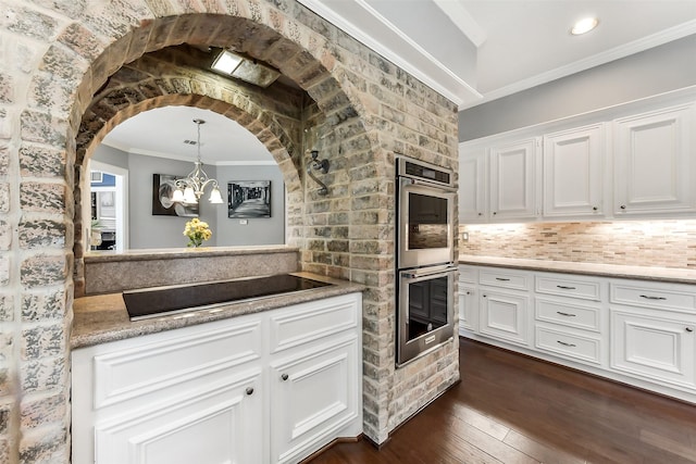 3230 Ivy Falls Dr, Houston, TX 77068 - kitchen with stainless steel double oven, ornamental molding, dark wood-type flooring, white cabinets, and black electric cooktop