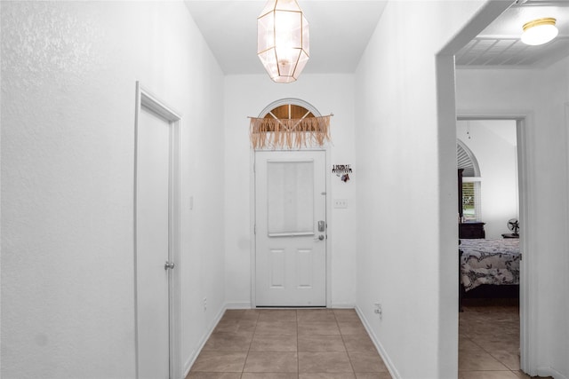 doorway featuring light tile patterned flooring and baseboards