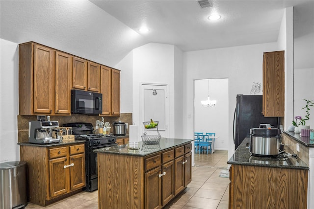 kitchen featuring black appliances, lofted ceiling, light tile patterned flooring, dark stone countertops, and tasteful backsplash