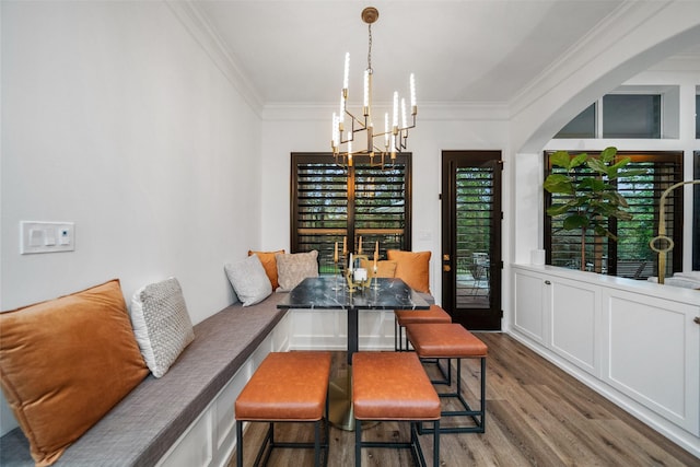 1924 Boulder Ridge Dr, Conroe, TX 77304 - dining space with a chandelier, ornamental molding, wood finished floors, arched walkways, and breakfast area