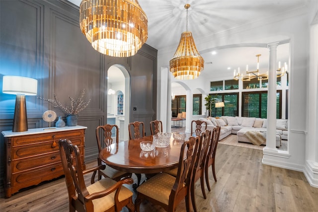 1924 Boulder Ridge Dr, Conroe, TX 77304 - dining space featuring a chandelier, arched walkways, light wood finished floors, and ornamental molding