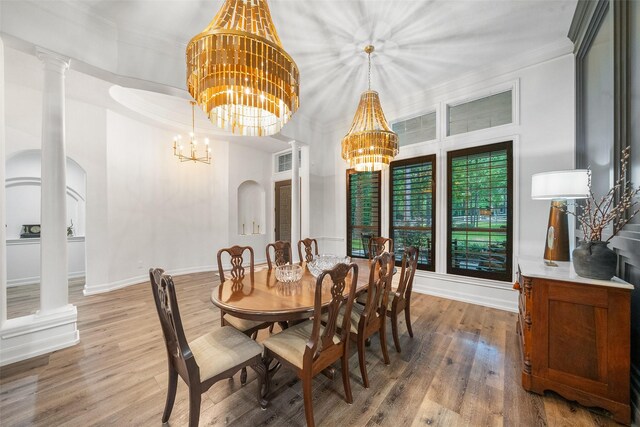 1924 Boulder Ridge Dr, Conroe, TX 77304 - dining room with a chandelier, arched walkways, wood finished floors, baseboards, and crown molding