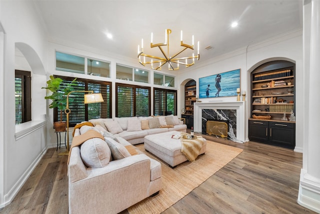 1924 Boulder Ridge Dr, Conroe, TX 77304 - living area featuring ornamental molding, a high end fireplace, a chandelier, built in features, and wood finished floors