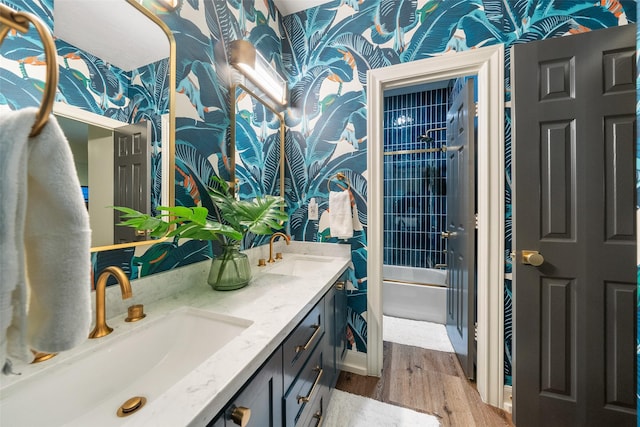 1924 Boulder Ridge Dr, Conroe, TX 77304 - full bath featuring wallpapered walls, wood finished floors, double vanity, tub / shower combination, and baseboards