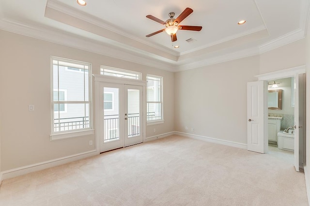 spare room featuring a raised ceiling, plenty of natural light, ornamental molding, and recessed lighting