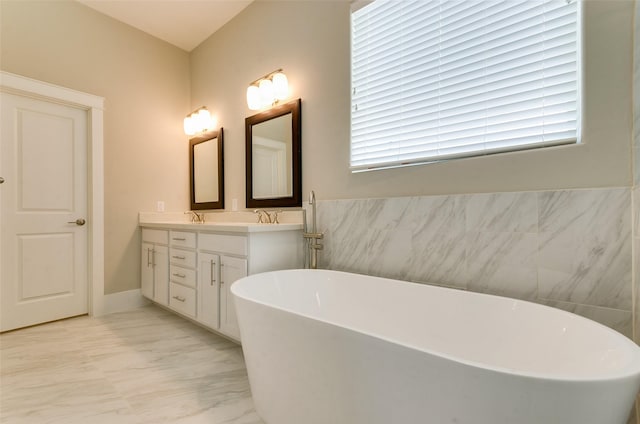 full bath with marble look tile flooring, a soaking tub, and double vanity
