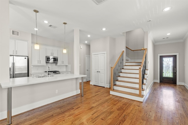 1814 Napa Creek Ln, Houston, TX 77009 - kitchen featuring stainless steel appliances, white cabinets, decorative backsplash, light countertops, and light wood-type flooring