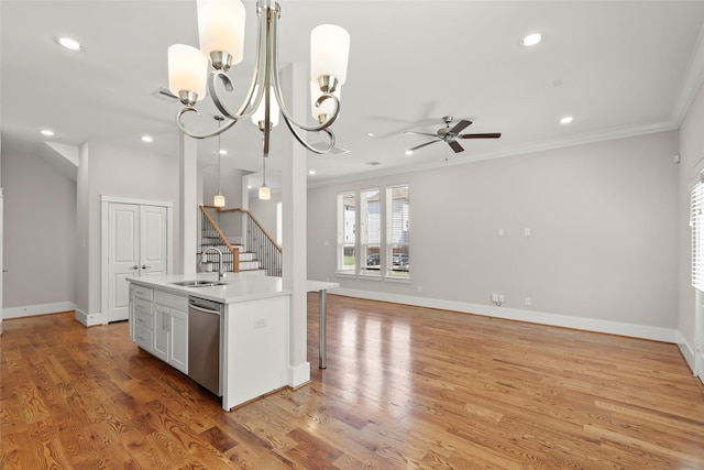 kitchen with a sink, dishwasher, crown molding, ceiling fan, and light wood-style floors