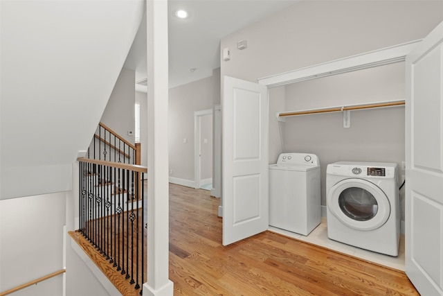 laundry room featuring separate washer and dryer and light wood-type flooring