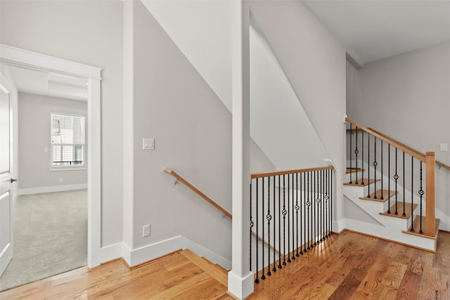 stairs with wood finished floors and baseboards