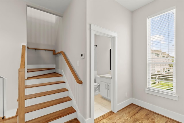 staircase with wood finished floors and baseboards