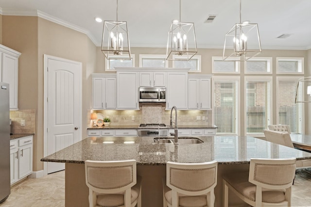514 Pearl View Ln, Pinehurst, TX 77362 - kitchen with stainless steel appliances, a sink, a chandelier, tasteful backsplash, and ornamental molding