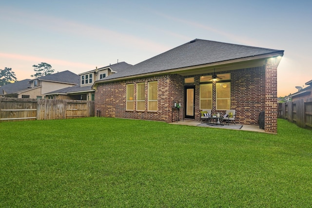 514 Pearl View Ln, Pinehurst, TX 77362 - back of property at dusk featuring brick siding, a patio area, ceiling fan, and roof with shingles
