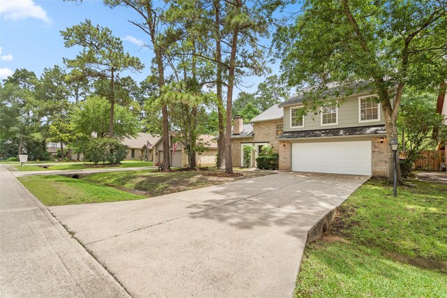 65 Hickory Oak Dr, The Woodlands, TX 77381 - traditional home featuring a garage, driveway, and brick siding