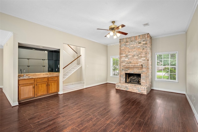 65 Hickory Oak Dr, The Woodlands, TX 77381 - unfurnished living room featuring ceiling fan, healthy amount of natural light, dark wood-style floors, baseboards, and ornamental molding