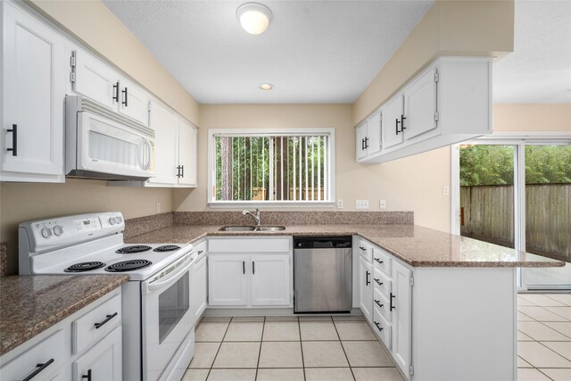 65 Hickory Oak Dr, The Woodlands, TX 77381 - kitchen with white appliances, a peninsula, a sink, healthy amount of natural light, and recessed lighting