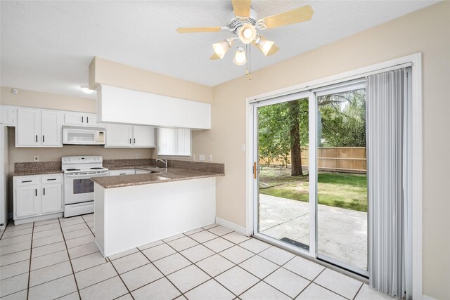 65 Hickory Oak Dr, The Woodlands, TX 77381 - kitchen featuring white appliances, a peninsula, a sink, and white cabinetry