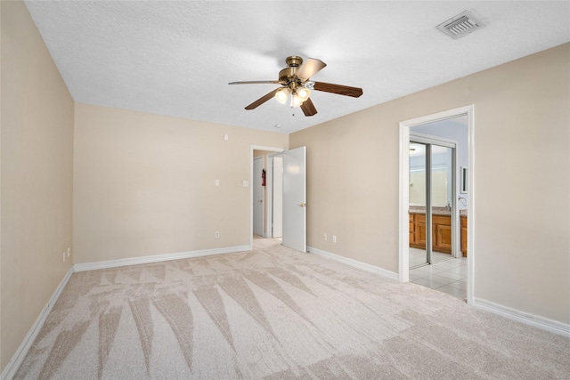 65 Hickory Oak Dr, The Woodlands, TX 77381 - unfurnished bedroom with light carpet, baseboards, ensuite bath, and ceiling fan