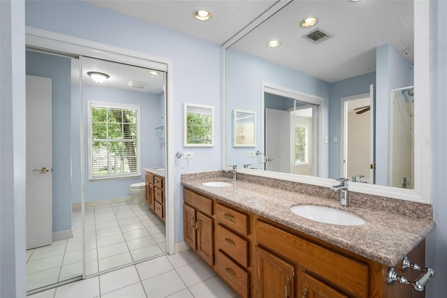 65 Hickory Oak Dr, The Woodlands, TX 77381 - bathroom with toilet, double vanity, tile patterned floors, baseboards, and recessed lighting