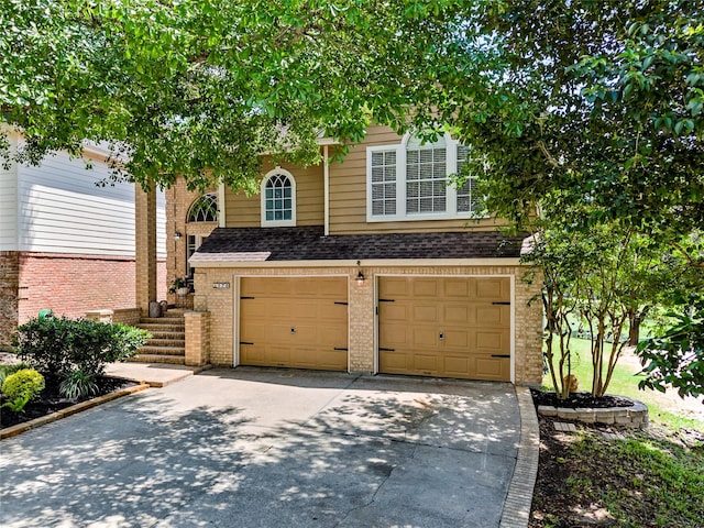170 April Cv, Montgomery, TX 77356 - view of front facade with driveway, a garage, brick siding, and a shingled roof