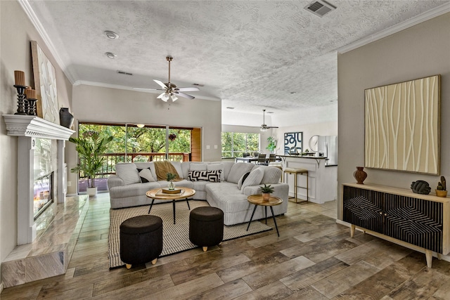 170 April Cv, Montgomery, TX 77356 - living room featuring ceiling fan, wood finished floors, a textured ceiling, and crown molding