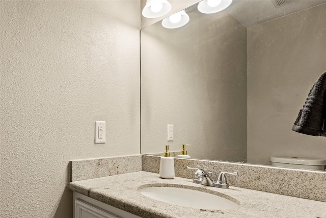 170 April Cv, Montgomery, TX 77356 - half bathroom featuring vanity, a textured wall, and toilet