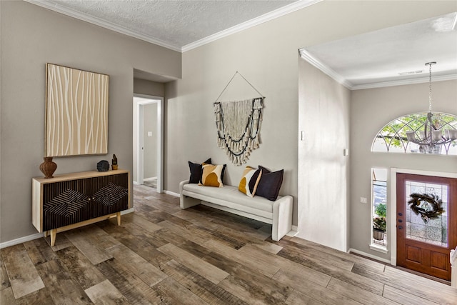 170 April Cv, Montgomery, TX 77356 - foyer featuring a chandelier, wood finished floors, crown molding, baseboards, and a textured ceiling