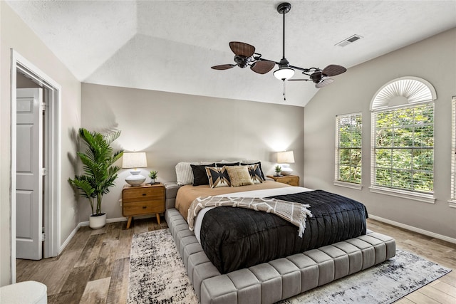 170 April Cv, Montgomery, TX 77356 - bedroom with lofted ceiling, light wood finished floors, a textured ceiling, baseboards, and a ceiling fan