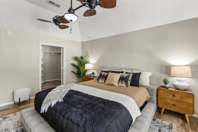 170 April Cv, Montgomery, TX 77356 - bedroom featuring wood finished floors, vaulted ceiling, a spacious closet, ceiling fan, and baseboards