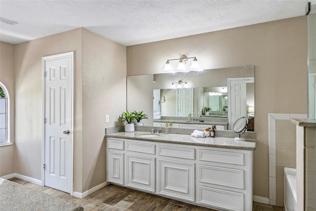 170 April Cv, Montgomery, TX 77356 - bathroom with wood finished floors, vanity, a bathtub, and baseboards