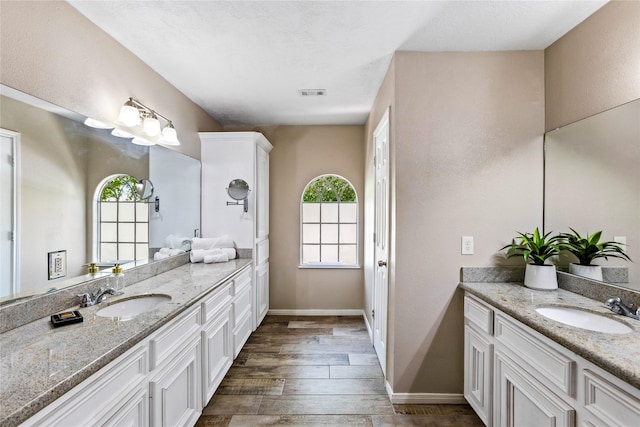 170 April Cv, Montgomery, TX 77356 - bathroom with two vanities, wood finished floors, and baseboards