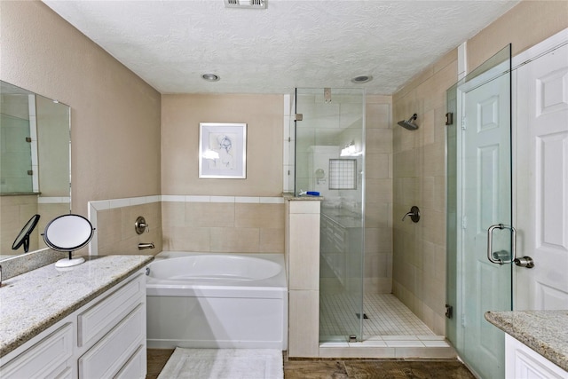 170 April Cv, Montgomery, TX 77356 - full bath with a stall shower, vanity, a bath, and a textured ceiling