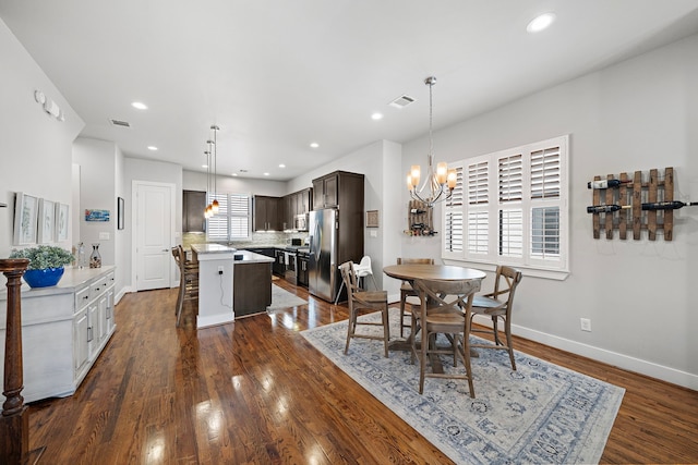 dining room featuring dark wood-type flooring, a chandelier, baseboards, and recessed lighting