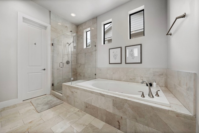 bathroom featuring a tub with jets and a stall shower