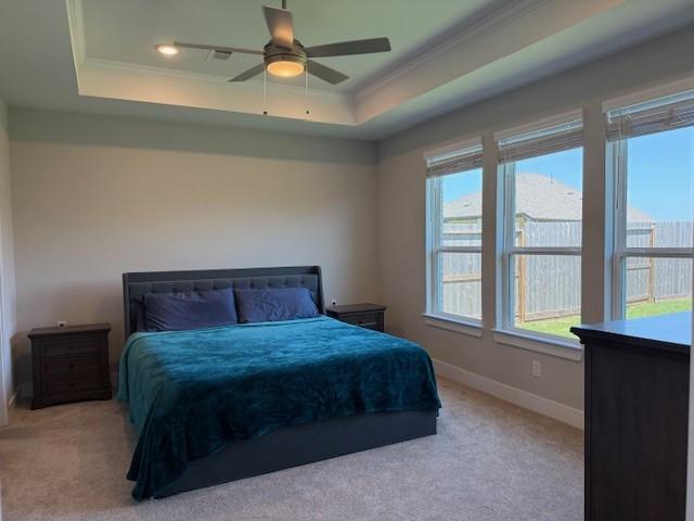 18714 Sweetwater Springs Dr, Cypress, TX 77433 - bedroom featuring a tray ceiling, light colored carpet, ornamental molding, baseboards, and a ceiling fan