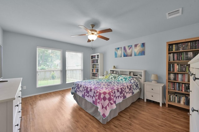 bedroom featuring wood finished floors, baseboards, and a ceiling fan