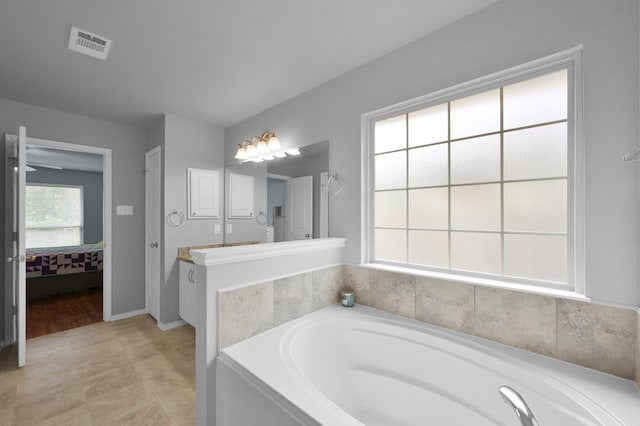 bathroom with connected bathroom, a garden tub, vanity, and baseboards