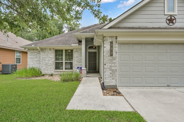 single story home featuring a front yard, a shingled roof, driveway, an attached garage, and central AC