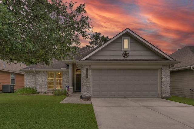ranch-style home with concrete driveway, a garage, a front yard, cooling unit, and brick siding