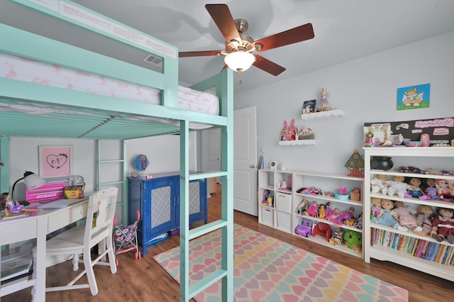 bedroom featuring wood finished floors, a desk, and ceiling fan