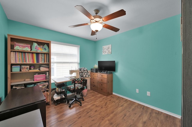 office space with a ceiling fan, wood finished floors, and baseboards