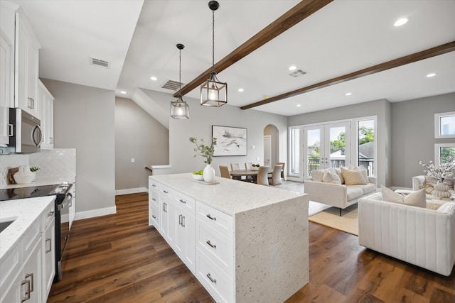 3104 Eunice St, Houston, TX 77009 - kitchen with stainless steel microwave, arched walkways, black range with electric stovetop, open floor plan, and tasteful backsplash
